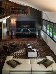 a living room with couches, tables and a large television in the middle of it