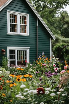 a green house surrounded by flowers and trees