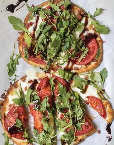 four slices of pizza with various toppings on them sitting on top of a piece of parchment paper