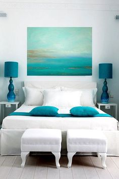 a bedroom with white furniture and blue accents