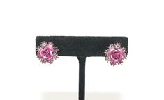 This item is a pair of vintage Avon silver tone, pink rhinestones and pink enamel flower stud earrings. Avon hallmarks. Give the gift of flowers that never wilt. Lovely earrings for anytime wear.  DETAILS:  ☼ Approximately 5/8 by 5/8 inches. ☼ Approximately 4.7 grams, total weight. ☼ ☼ ☼ ☼ ☼ ☼ ☼ ☼ ☼ ☼ ☼ ☼ ☼ ☼ ☼ ☼ ☼ ☼ ☼ ☼ ☼ PLEASE NOTE:  ☼ Different items on SALE everyday!  Check back often to take advantage of these bargains! ☼ FREE DOMESTIC SHIPPING on purchases of $35 or more.  Combined shippi Pink Flower-shaped Evening Jewelry, Pink Clip-on Jewelry For Anniversary, Pink Flower Earrings For Evening, Pink Clip-on Earrings For Anniversary, Pink Vintage Earrings For Anniversary, Pink Clip-on Jewelry For Evening, Vintage Pink Flower Earrings For Party, Pink Rhinestone Earrings For Formal Occasions, Formal Pink Rhinestone Earrings