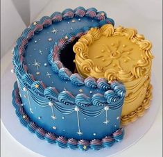 there is a blue and gold cake with stars on the top one has an elaborately decorated design