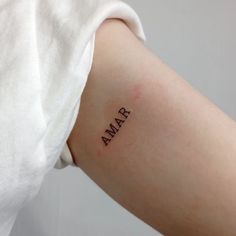 a woman's arm with the word amar tattooed on her left side shoulder