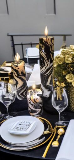 a table set with black and gold place settings