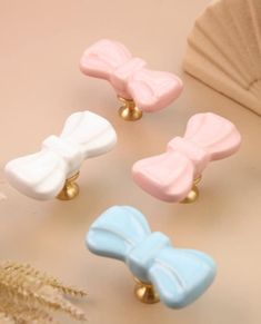 four different colored bow shaped knobs on a table