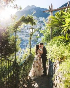 a bride and groom kissing on the steps to their wedding ceremony in positi, italy