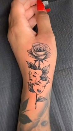 a woman's arm with a rose and two faces tattooed on the left side