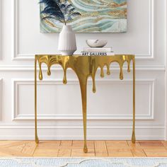 a gold console table with dripping paint on it