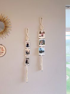 two pictures hang on the wall with tassels attached to them, next to a mirror