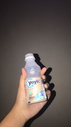 a person holding a bottle of yogurt in their hand