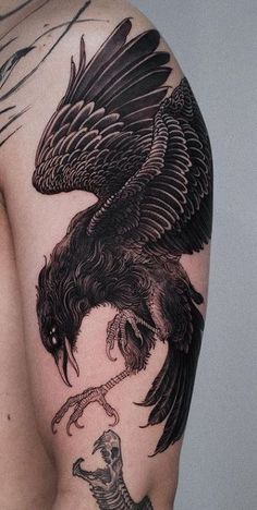 a man with a tattoo on his arm has a large black bird perched on it's shoulder