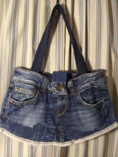 Handcrafted from recycled jeans. You will get noticed with this one of a kind bag.  Measures 18 inches wide by 11 inches long. Strap drop is 11 inches.  2 pockets inside, 4 outside. Button closure. Inside area measures 16 inches by 8 inches. Recycled Jeans Bag, Jean Bag, Ashley Black, Recycled Jeans, Upcycle Jeans, Black And White Skirt, Diy Sewing Clothes, Old Jeans, Jeans Bag