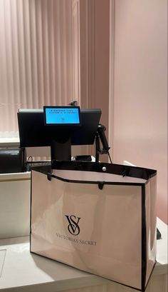 a shopping bag sitting on top of a counter next to a computer monitor and keyboard