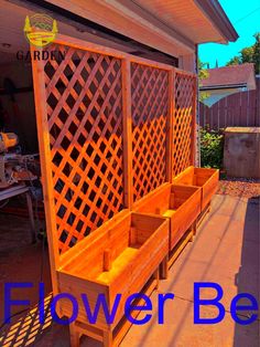 a wooden bench sitting in the middle of a yard next to a fence with flowers on it