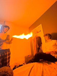 two people standing in a bedroom with flames coming out of their mouths and hands on the bed