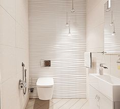 a modern bathroom with white tile walls and flooring, along with a toilet and sink