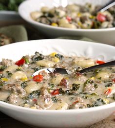 two white bowls filled with food on top of a table