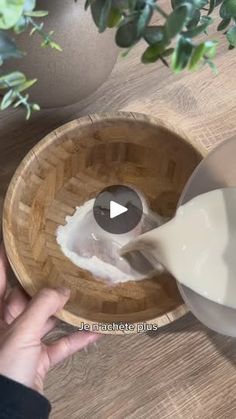 a person pouring milk into a wooden bowl