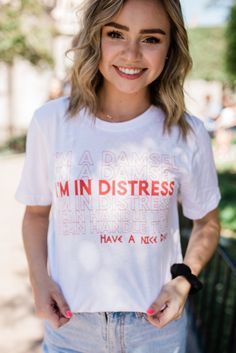 a woman wearing a white t - shirt that says i'm in distresss