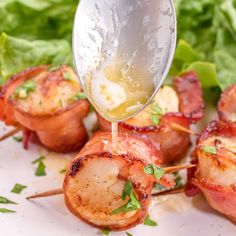 bacon wrapped scallops being drizzled with lemon