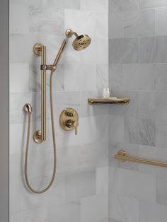 a shower with gold fixtures in a bathroom