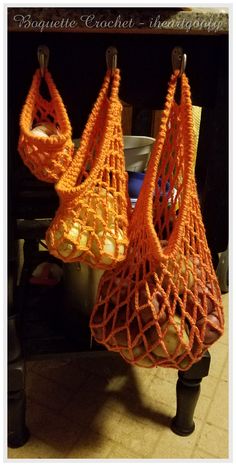 two orange bags hanging from hooks in a kitchen