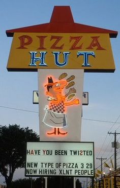 a neon sign for a pizza hut with a cartoon character on it's side