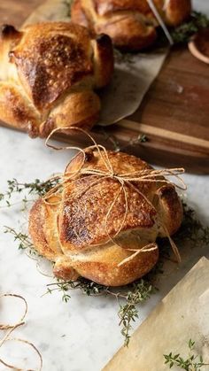 some breads are on a cutting board and tied with twine