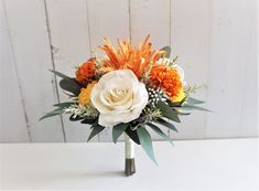 an orange and white flower arrangement in a vase