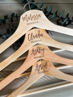 three wooden hangers with names on them