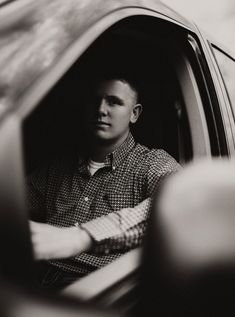 a man sitting in the passenger seat of a car