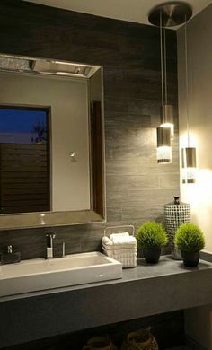 a bathroom with a sink, mirror and lights on the side of the wall above it