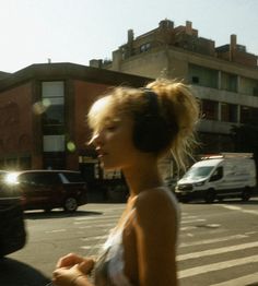 a woman with headphones walking down the street