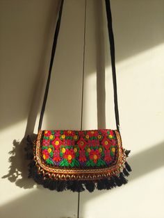 A very stylish and eye- catching sling bag for women is handmade from vintage and authentic textiles. This bag looks attractive with a foldover shape and hidden magnetic fastening. This bag comes with a strap to use for crossbody or shoulder style wearing. There are two zippered compartments inside to carry your valuables. This sling bag is sewn together and embellished with exquisite embroidery.The materials of this bag are vintage which are collected over the course of many years by nomadic tr Bohemian Clutch Bag With Tassels, Bohemian Tassel Clutch Bag, Multicolor Tassel Pouch Bag, Black Bohemian Pouch Clutch, Bohemian Black Pouch Clutch, Bohemian Black Clutch For Everyday Use, Bohemian Clutch Shoulder Bag With Tassels, Bohemian Tassel Clutch Shoulder Bag, Traditional Multicolor Bag With Adjustable Strap