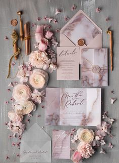 the wedding stationery is laid out with pink flowers