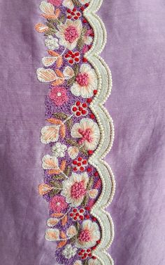 a close up of a purple shirt with flowers on the front and side, along with white trim