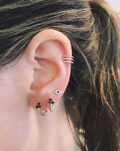 a close up of a person's ear with three different types of piercings