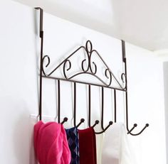 a rack with towels hanging from it's sides next to a wall mounted oven mitt