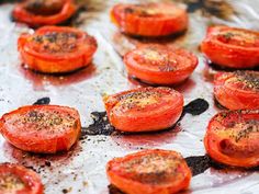 sliced tomatoes on a baking sheet ready to go in the oven for roasting or cooking