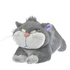 a gray stuffed animal with green eyes laying down on the ground next to a white background