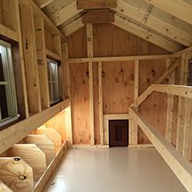 the inside of a building with wooden walls and windows