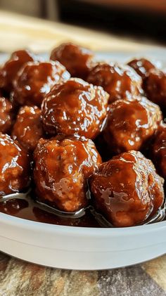 a white plate filled with meatballs covered in brown gravy on top of a table