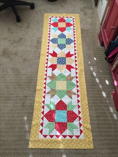 a quilted table runner is sitting on the floor