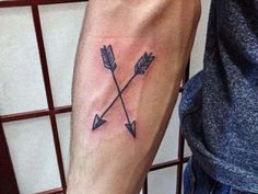 a man's arm with an arrow tattoo on it