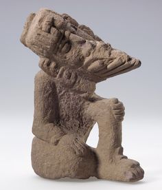 a stone sculpture of a sitting bear