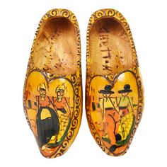 a pair of wooden shoes with painted images on them