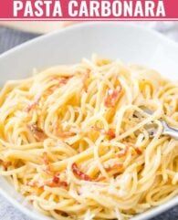 a white bowl filled with pasta on top of a table