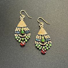 a pair of earrings with beaded details and beads hanging from the earwires