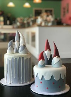 two decorated cakes sitting on top of a table next to each other in front of a counter