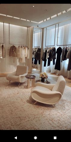 the inside of a clothing store with white furniture